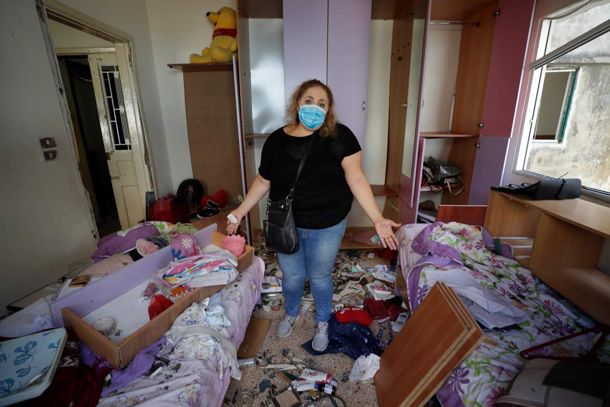 Mona Al Chami, poses for a photograph inside her destroyed apartment after Tuesday’s explosion in the seaport of Beirut, Lebanon, Aug. 6, 2020.