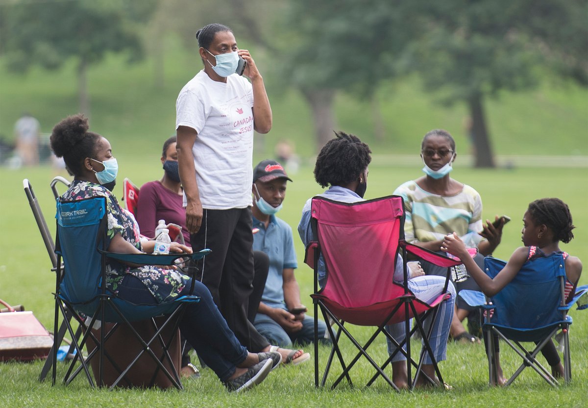 People wear face masks as they gather in a city park in Montreal, Sunday, August 9, 2020, as the COVID-19 pandemic continues in Canada and around the world. 