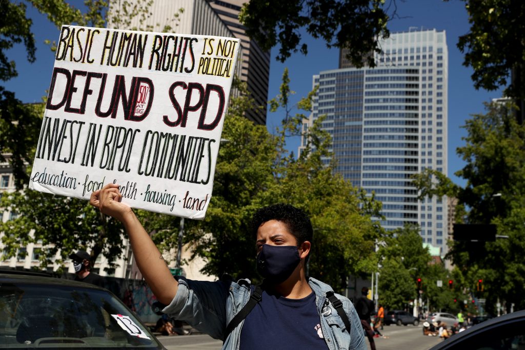 Protestors block Fourth Avenue outside Seattle City Hall during Monday's Seattle City Council budget committee voting, which included potential Seattle Police Department cuts, Monday, Aug. 10, 2020. Organizers said the protest puts pressure on defunding Seattle Police and reallocating funds into the Black community. 