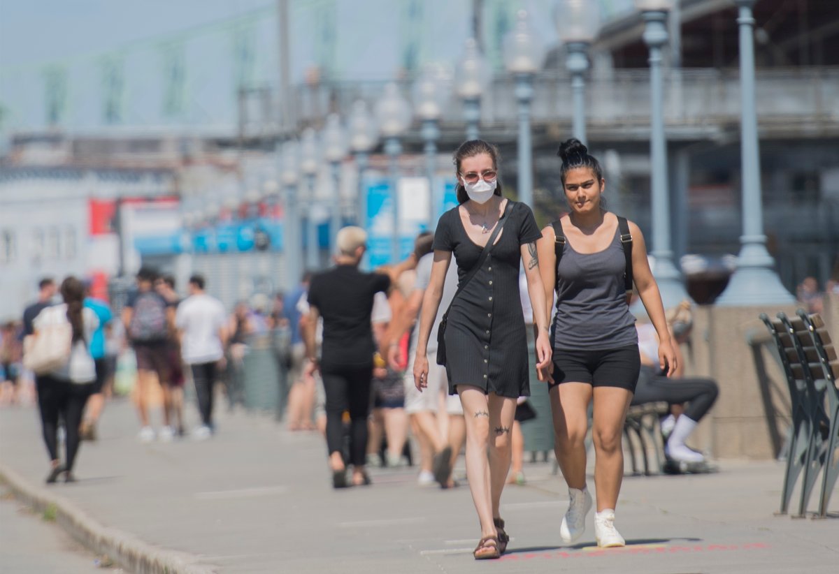 A woman wears a face mask as she walks along the promenade in the Old Port of Montreal, Sunday, August 16, 2020, as the COVID-19 pandemic continues in Canada and around the world. 