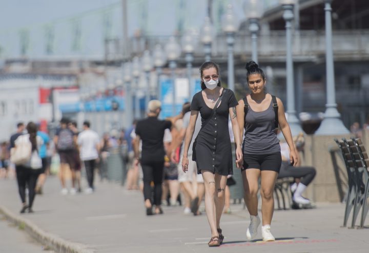 A woman wears a face mask as she walks along the promenade in the Old Port of Montreal, Sunday, August 16, 2020, as the COVID-19 pandemic continues in Canada and around the world. 