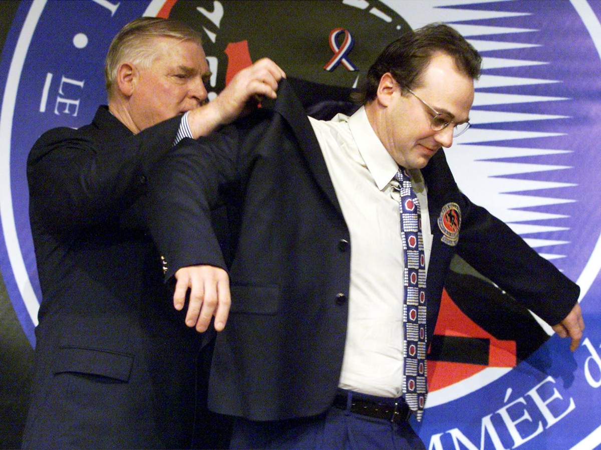 Hockey Hall of Fame chairman Bill Hay, left, helps inductee Dale Hawerchuk into his jacket at the induction ceremony in Toronto on November 12, 2001. Longtime Winnipeg Jets star Dale Hawerchuk has died after a battle with cancer. He was 57. THE CANADIAN PRESS/Frank Gunn