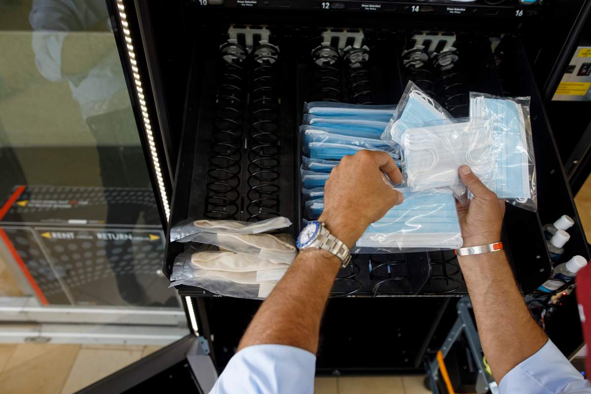 Gilad Levy refills a PPE vending machine at Yorkdale Shopping Centre in Toronto, Thursday, Aug. 13, 2020. THE CANADIAN PRESS/Cole Burston