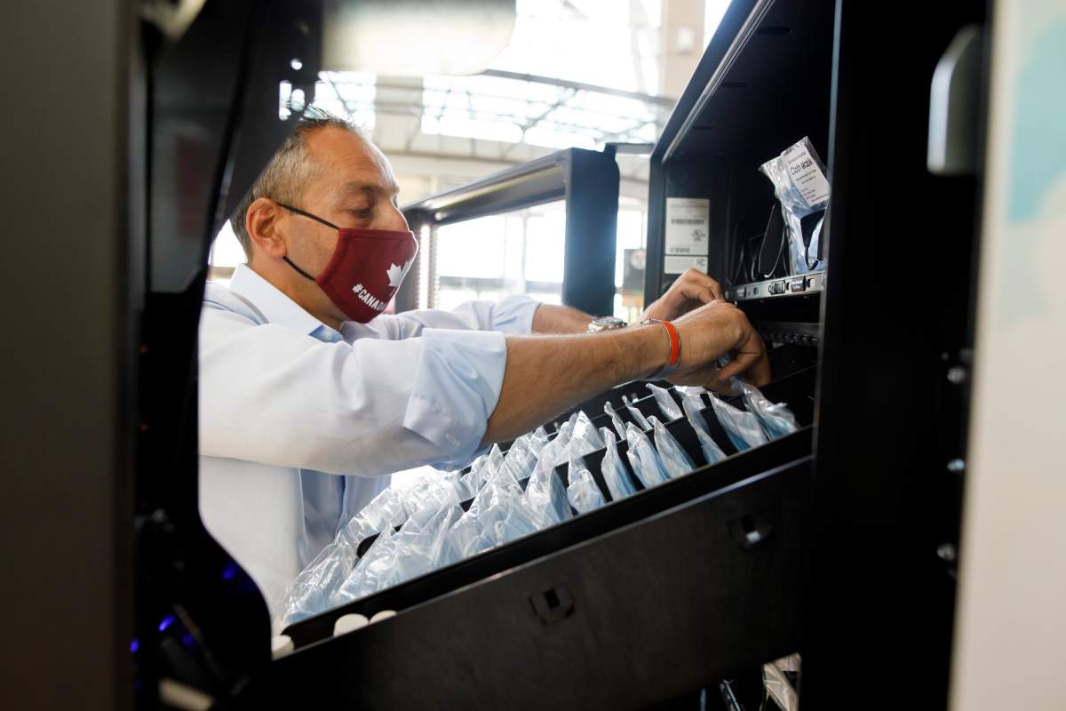 Gilad Levy refills a PPE vending machine at Yorkdale Shopping Centre in Toronto, Thursday, Aug. 13, 2020. 