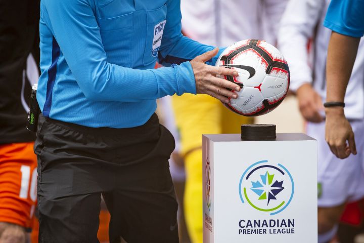 A referee takes the game ball from a pedestal at the beginning of the inaugural soccer match of the Canadian Premier League between Forge FC of Hamilton and York 9 in Hamilton, Ont., Saturday, April 27, 2019. 