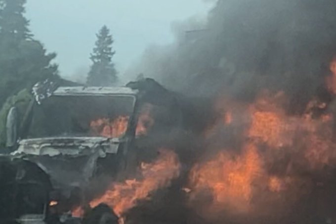 A photo shows a transport truck engulfed in flames and smoke.