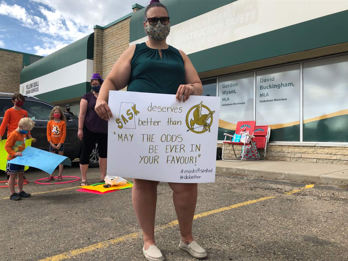 A protester holds up a sign in front of Minister of Education Gord Wyant’s office on Friday.