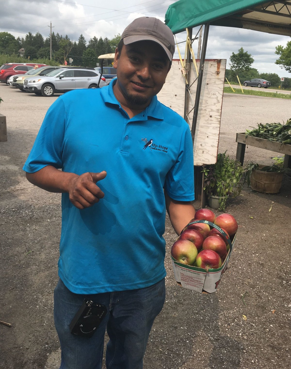 Raul Gonzales, a temporary worker from Mexico, holds apples he helped to grow at Hy-Hope Farm in Ashburn, Ont., in 2018.