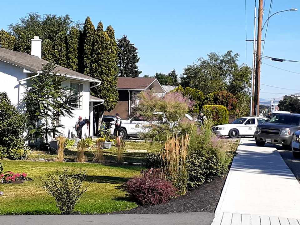 Officers and police vehicles block a home along the 400 block of Rutland Road South in Kelowna on Wednesday.