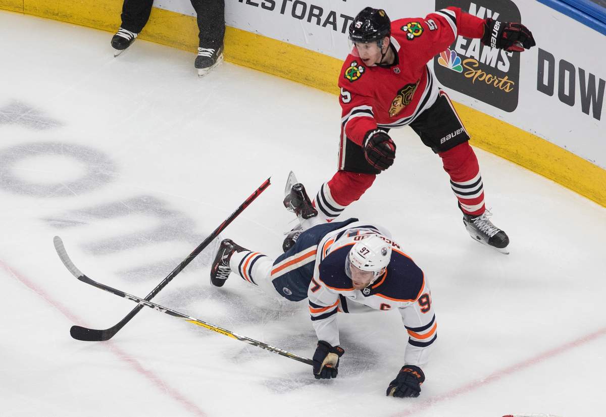 Edmonton Oilers' Connor McDavid (97) is checked by Chicago Blackhawks' Connor Murphy (5) during second period NHL qualifying round game action in Edmonton, on Friday August 7, 2020.