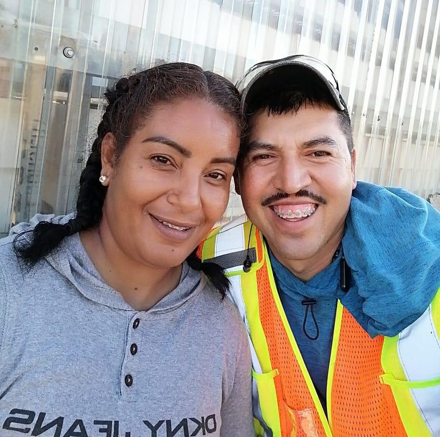 Erika Zavala (left) and Jesús Molina take a photo together at Bylands, the B.C. farm that fired them in July for inviting two people onto the property. Bylands tells Global News this violated their policy about “having visitors on site.”