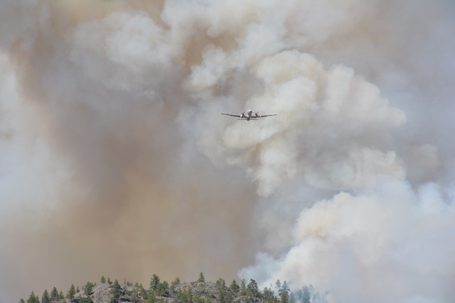 A plane can be seen in front of a wall of smoke from a wildfire that’s burning near Skaha Lake between Penticton and Okanagan Falls.