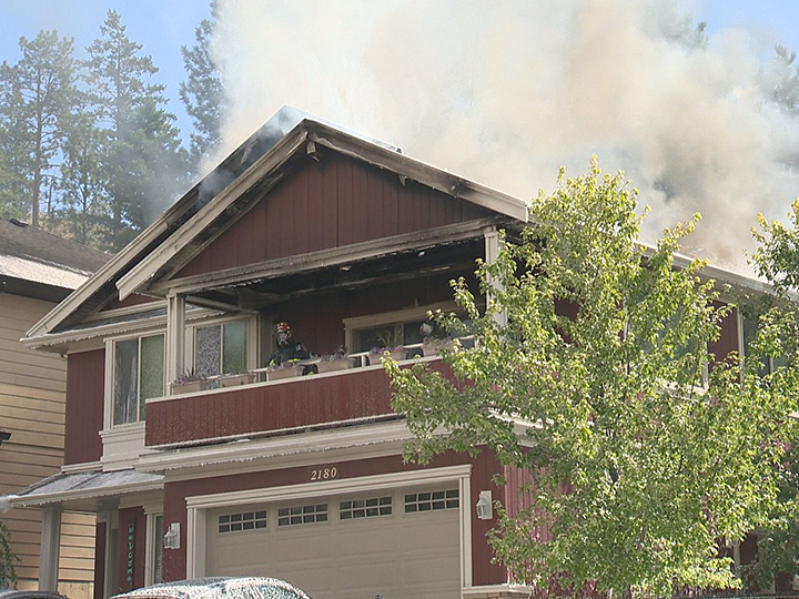 Smoke billows from the roof of a West Kelowna home on Thursday morning.