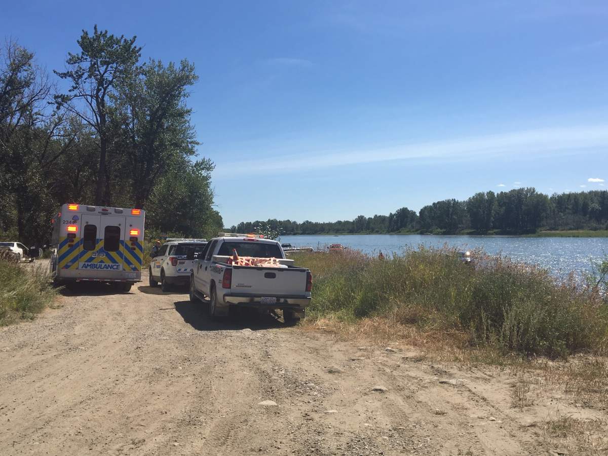 Officials remain on scene at the Bow River in Carseland, Alta., on Aug. 10, searching for a man who went missing in the river on Sunday.