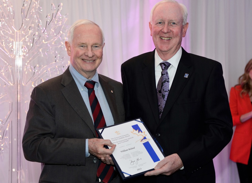 Bill Boland, right, as seen receiving the Caring Canadian Award from then-Governor General David Johnston, left, on March 17, 2013.