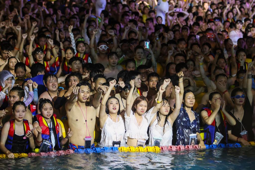 This photo taken on Aug. 15, 2020 shows people watching a performance as they cool off in a swimming pool in Wuhan in China’s central Hubei province.