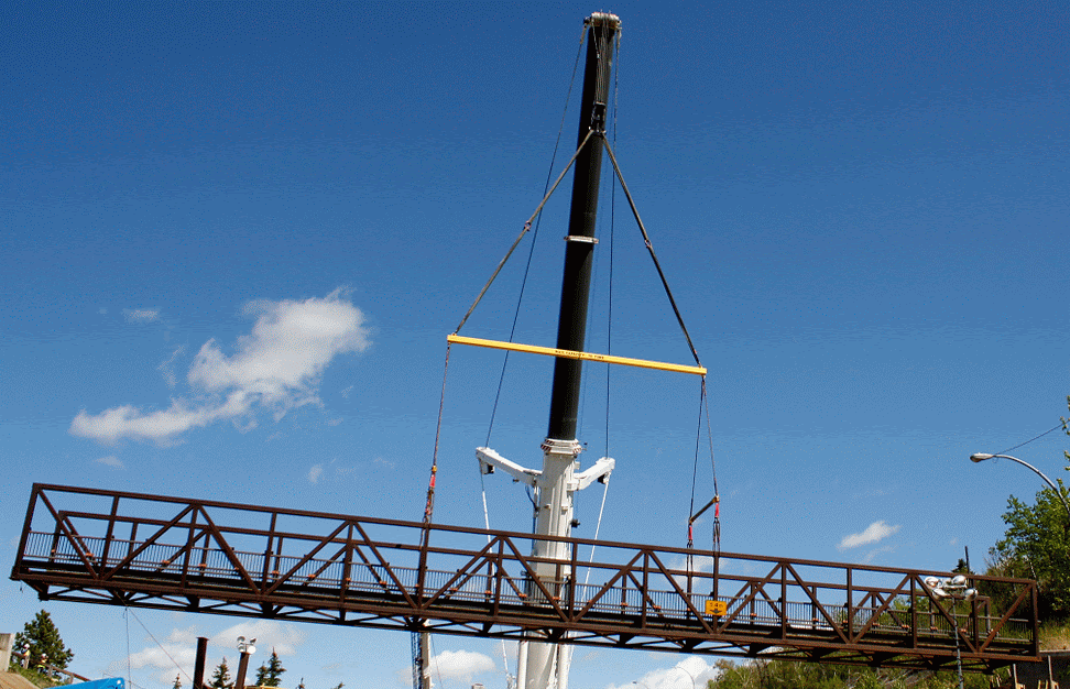 The bridge is picked up by a crane, ready to be loaded up.