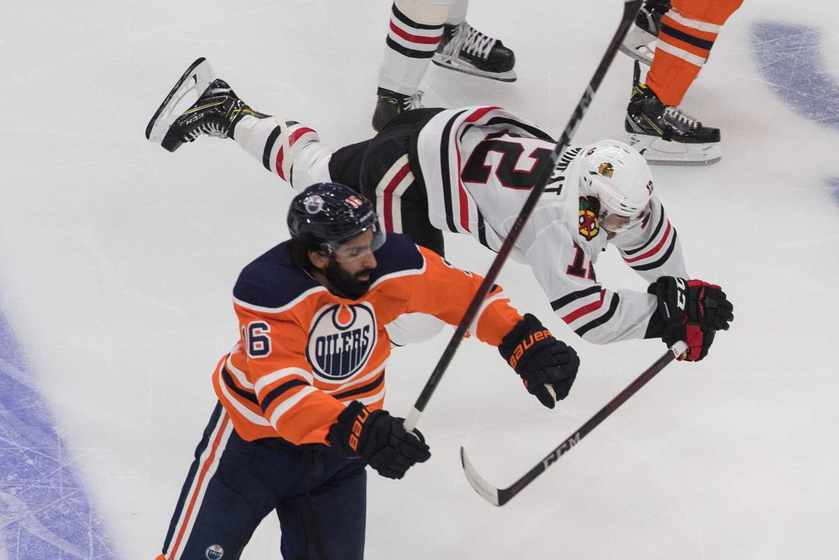 Edmonton Oilers' Jujhar Khaira (16) checks Chicago Blackhawks' Alex DeBrincat (12) during second period NHL playoff action in Edmonton, Saturday, Aug. 1, 2020. THE CANADIAN PRESS/Jason Franson.