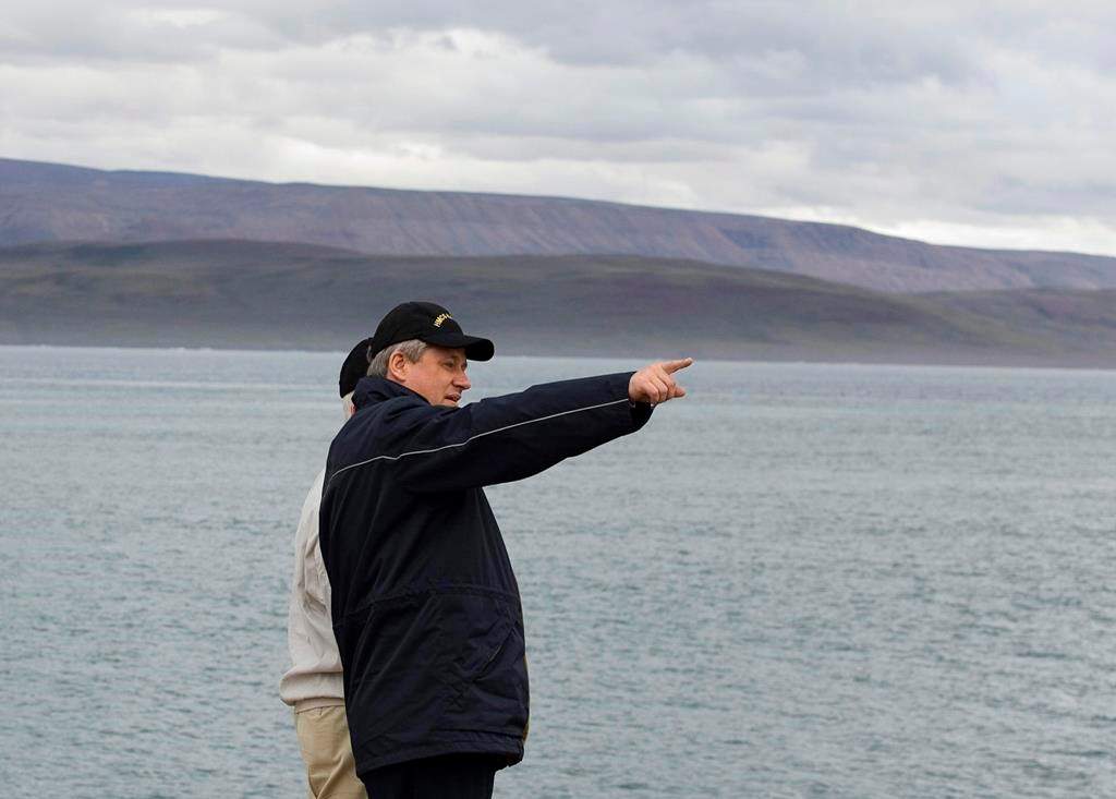 Prime Minister Stephen Harper looks down the shoreline in the Arctic port of Nanisivik, Nunavut on August 10, 2007. The construction of a new military refuelling station in the Arctic is facing yet another delay more than 13 years after it was first promised by the federal government.