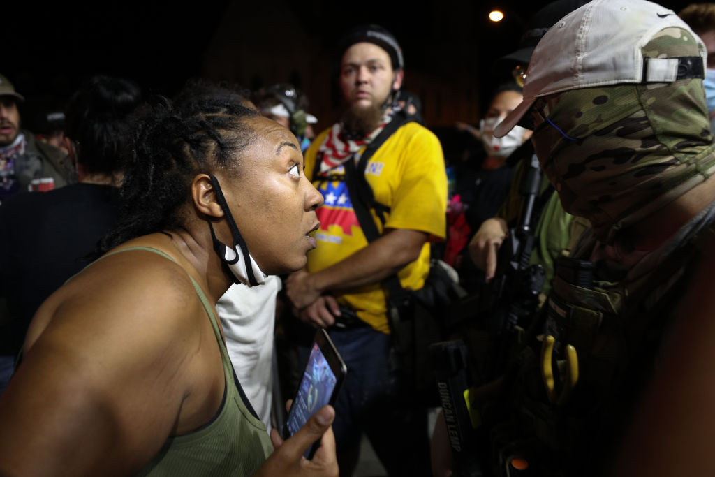 Armed civilians stand in the streets of Kenosha during the third day of protests over the shooting of a Black man, Jacob Blake, by a police officer in Wisconsin on Aug. 25, 2020.