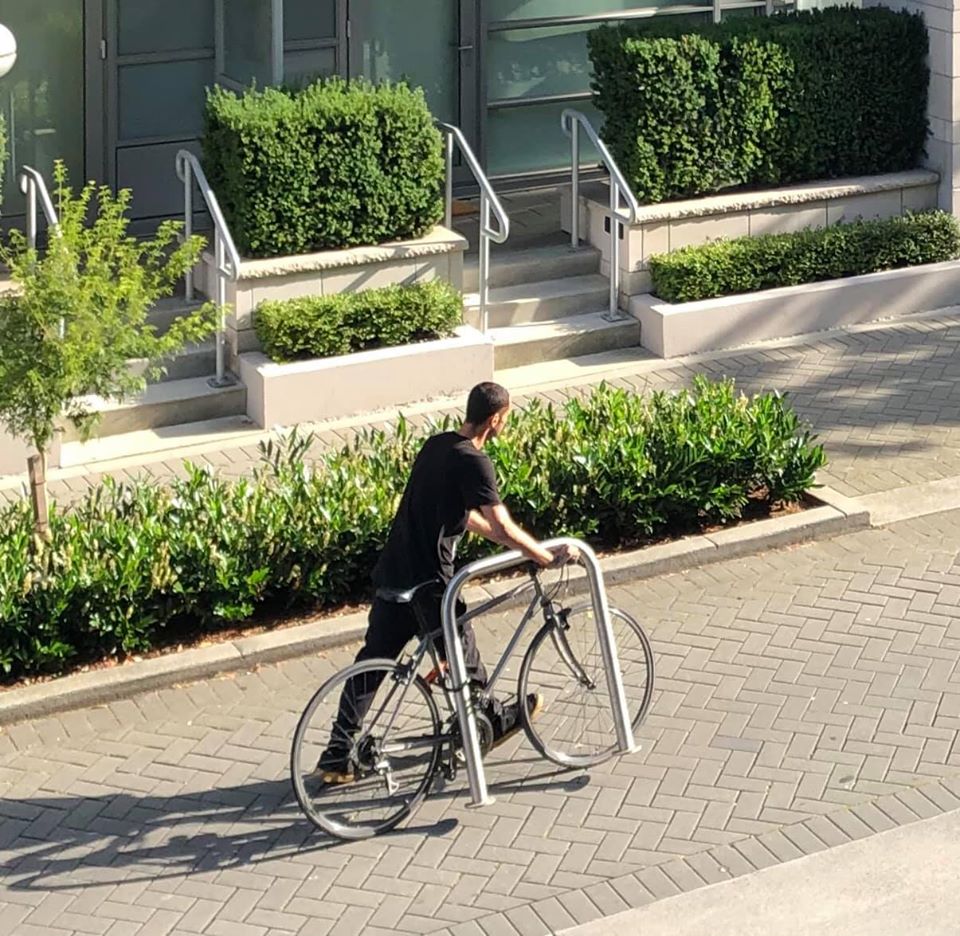 A man is seen strolling through Vancouver’s Olympic Village on Aug. 19 with a bike and bike rack.