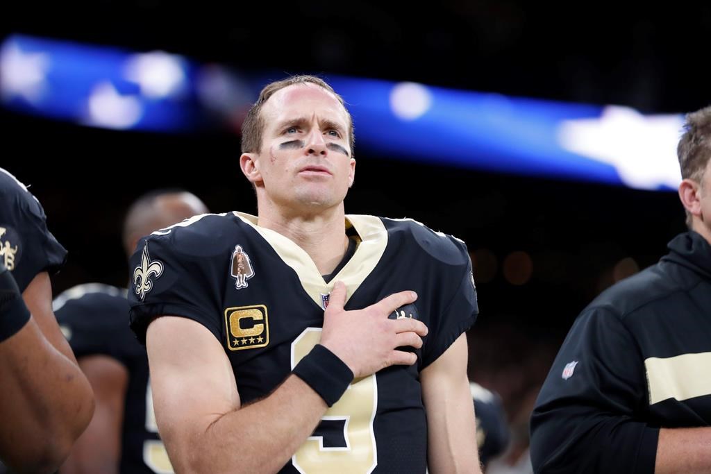 FILE - In this Dec. 23, 2018, file photo, New Orleans Saints quarterback Drew Brees (9) holds his hand to his heart during the national anthem before an NFL football game against the Pittsburgh Steelers in New Orleans.