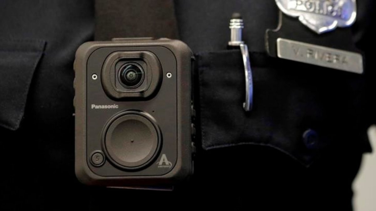 A Newark police officer displays how a body cam is worn during a news conference unveiling new cameras at the Panasonic headquarters in Newark, N.J.