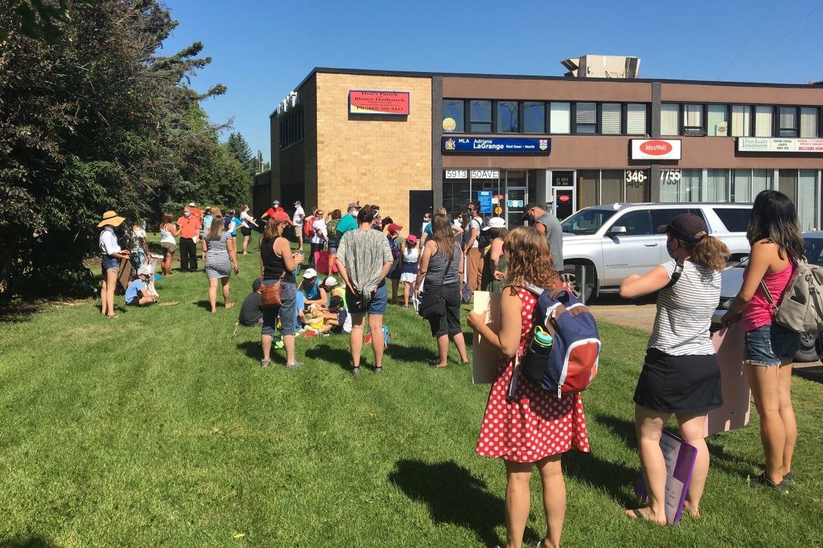 People ralled outside the Alberta education minister's office in Red Deer on Tuesday, Aug. 18, 2020.