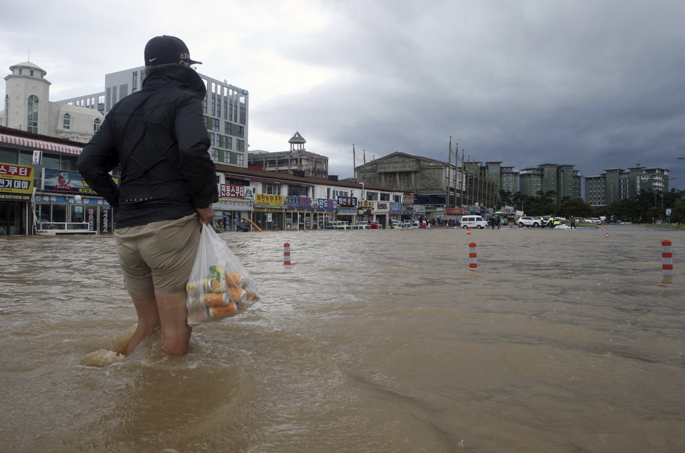 A citizen walks through a flooded area in Gangneung, South Korea, Thursday, Sept. 3, 2020. A powerful typhoon ripped through South Korea’s southern and eastern coasts with tree-snapping winds and flooding rains Thursday, knocking out power to thousands of homes. 