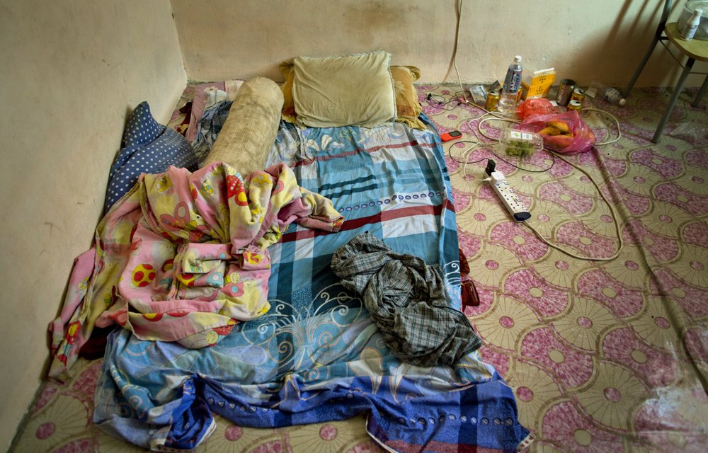Pillows and blankets are seen in the sleeping area of Bangladeshi palm oil worker, Karim, at a house he shares with others in peninsular Malaysia, Wednesday, March 6, 2019.