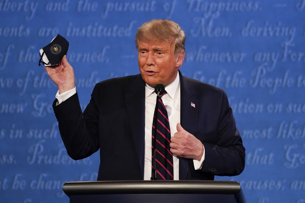 President Donald Trump holds up his face mask during the first presidential debate Tuesday, Sept. 29, 2020, at Case Western University and Cleveland Clinic, in Cleveland, Ohio. 
