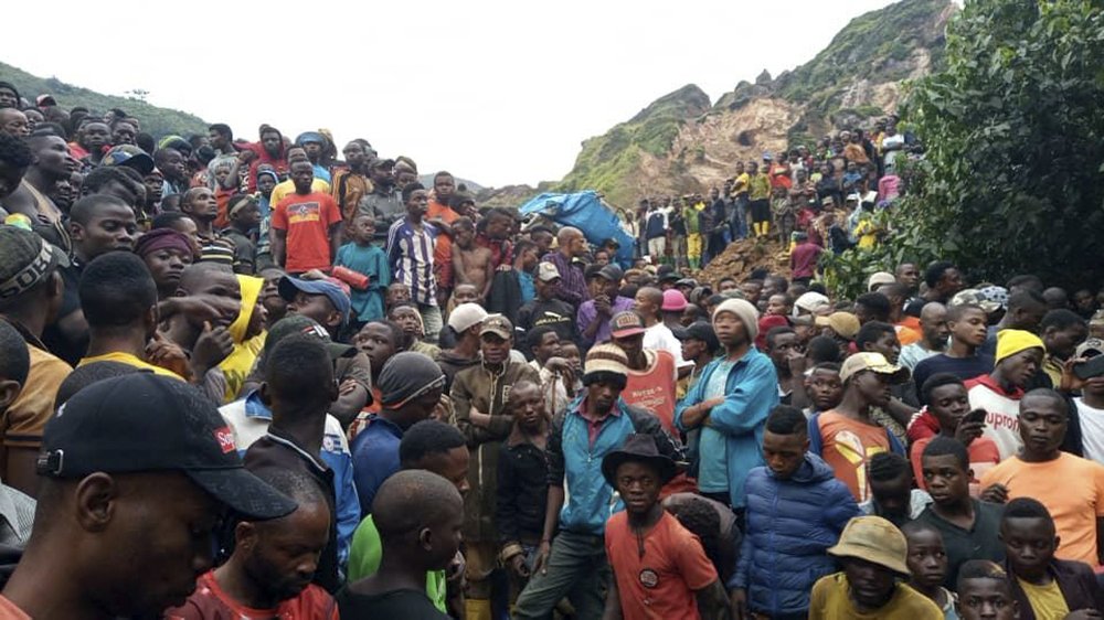 People gather at the scene of a gold mine collapse near the town of Kamituga, South Kivu province, in eastern Congo Friday, Sept. 11, 2020. More than 50 people are dead after landslides collapsed three artisanal gold mines near the town of Kamituga in eastern Congo's South Kivu province on Friday, officials said.
