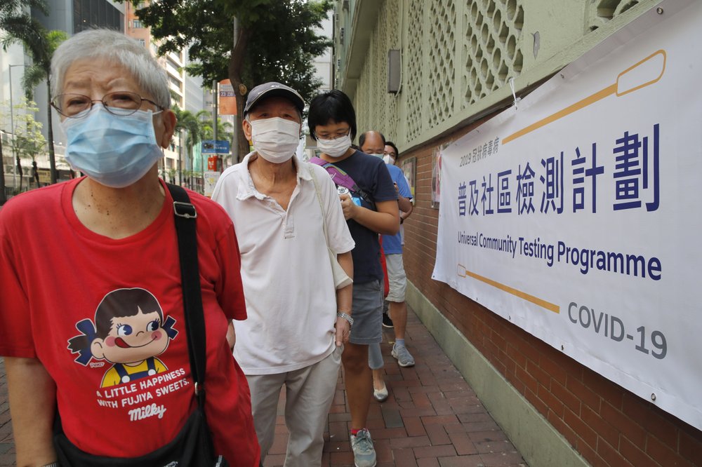 People wearing face masks queue for the coronavirus test outside a testing center in Hong Kong, Tuesday, Sept. 1, 2020. Hong Kong began a voluntary mass-testing program for coronavirus Tuesday as part of a strategy to break the chain of transmission in the city's third outbreak of the disease. The virus-testing program has become a flash point of political debate in Hong Kong, with many distrustful over resources and staff being provided by the China's central government and fears that the residents’ DNA could be collected during the exercise.