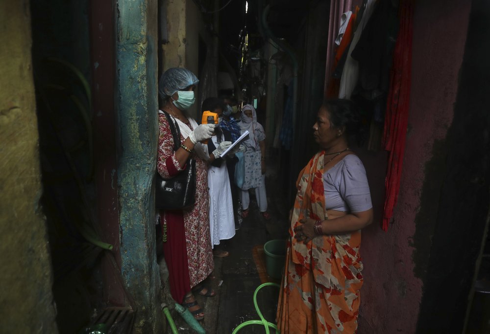 A health worker screens people for symptoms of COVID-19 in Dharavi, one of Asia's biggest slums, in Mumbai, India, Friday, Sept. 4, 2020.The number of people infected with the coronavirus in India rose by another 80,000 and is near Brazil's total, the second-highest in the world. 