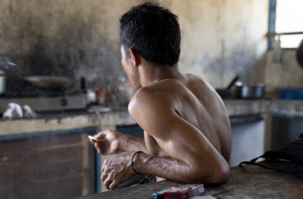 An Indonesian migrant worker rests after working on a palm oil plantation run by the government-owned Felda in Malaysia, in early 2020. Jum, a former worker who escaped from this same plantation, described to The Associated Press how the company confiscated, described sleeping on the ground, exposed to the wind and monsoon rains, with only a campfire to fend off snakes and tiger.
