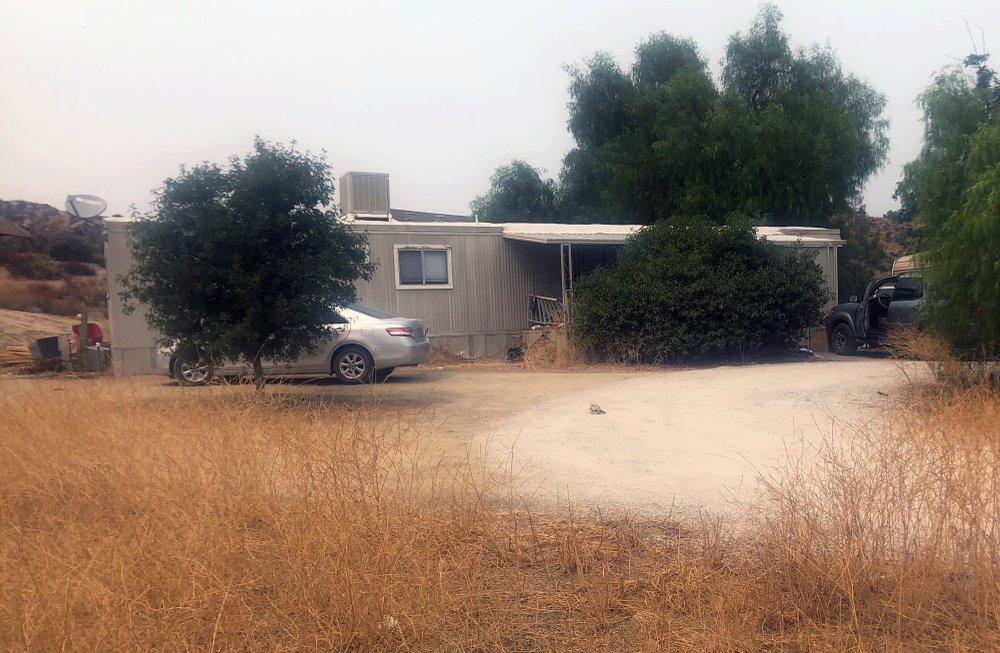 A car is left parked at a house where killings occurred in the rural town Aguanga, Calif., Tuesday, Sept. 8, 2020. Seven people were found fatally shot at an illegal marijuana growing operation in Aguanga. The crime scene was discovered before dawn Monday, Sept. 7, after deputies responded to a report of an assault with a deadly weapon at a home in the unincorporated community of Aguanga, north of San Diego, the Riverside County Sheriff's Department said in a statement. 