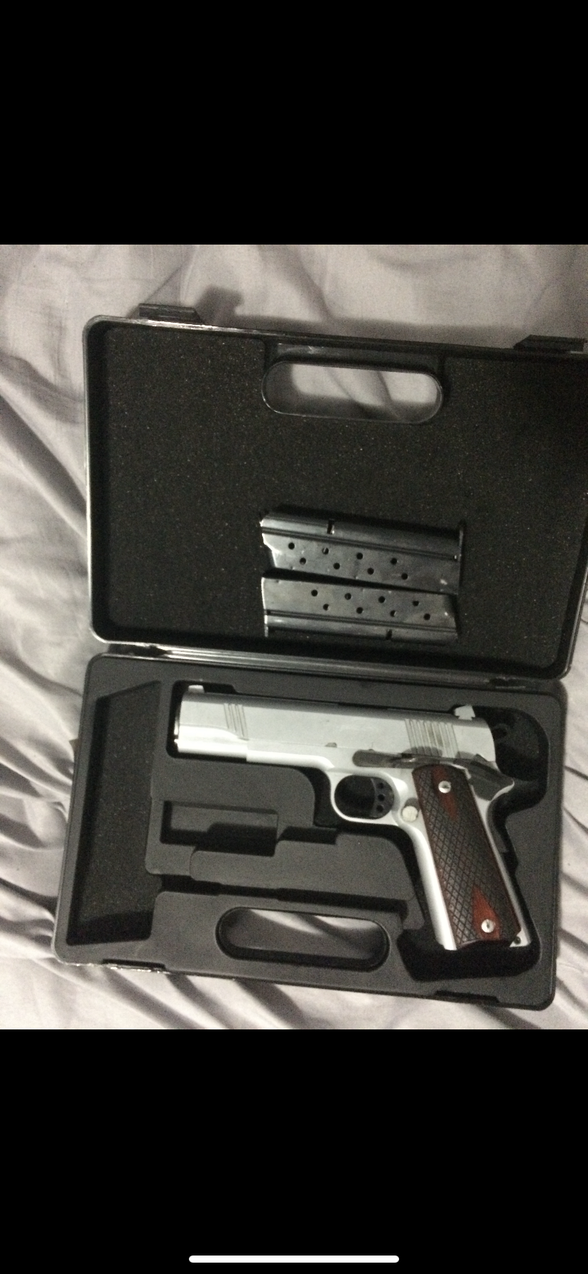 The firearm is described as a silver Norinco 1911, 9mm handgun with brown grips and contains two magazines.