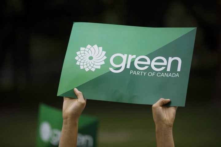 A supporter holds a sign for the Green Party of Canada in Toronto, Tuesday, Sept. 3, 2019. 