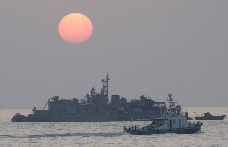 FILE - In this Dec. 22, 2010, file photo, a government ship sails past the South Korean Navy's floating base as the sun rises near Yeonpyeong island, South Korea. A South Korean official who disappeared off a government ship near the disputed sea boundary with North Korea this week may be in North Korea, South Korea's Defense Ministry said Wednesday, Sept. 23, 2020. 