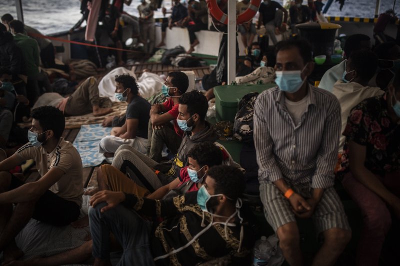 FILE - In this Sept. 9, 2020 file photo, migrants of different nationalities rest on board the Spanish NGO Open Arms vessel, after being rescued as they were trying to flee Libya on board a precarious wooden boat, in the Central Mediterranean Sea. Amnesty International said Thursday, Sept. 24, 2020, that thousands of Europe-bound migrants who were intercepted and returned to Libyan shores this year were forcefully disappeared after they were taken of detention centers run by militias allied with the U.N.-supported government in the capital, Tripoli. The report also said that rival authorities in eastern Libya forcibly expelled serval thousands “without due process or the opportunity to challenge their deportation.” .