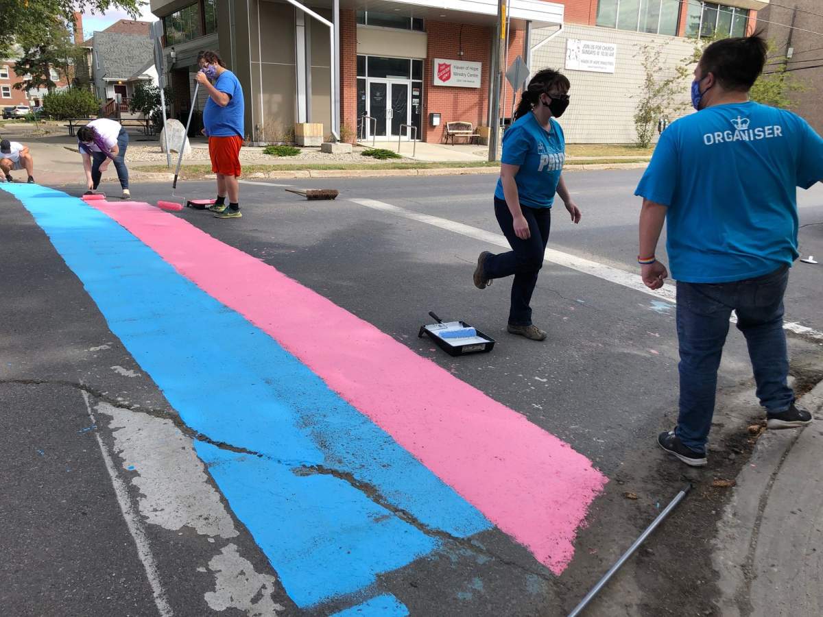 A transgender flag is painted by volunteers on Sunday at 13th Avenue and Lorne Street.