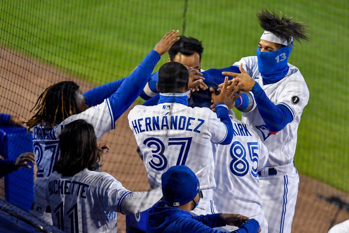 Toronto Blue Jays' Alejandro Kirk (85) is mobbed by teammates Vladimir Guerrero Jr., left, Teoscar Hernández (37) and Lourdes Gurriel Jr., right, after hitting a solo home run against the New York Yankees during the seventh inning of a baseball game in Buffalo, N.Y., Monday, Sept. 21, 2020.