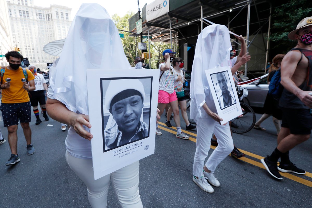 A participant, second from left, holds a portrait of Tony McDade, as another, right, holds a photo of Maurice Gordon Jr., killed by a New Jersey state trooper two days before the death of George Floyd, during a queer liberation march for Black Lives Matter and against police brutality, Sunday, June 28, 2020, in New York.