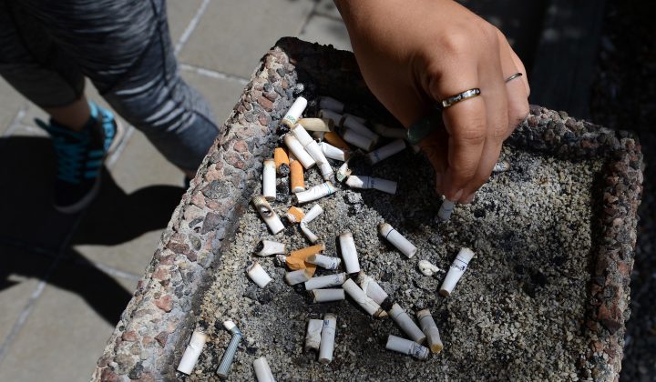 A smoker puts out a cigarette in a public ash tray in Ottawa on May 31, 2016.