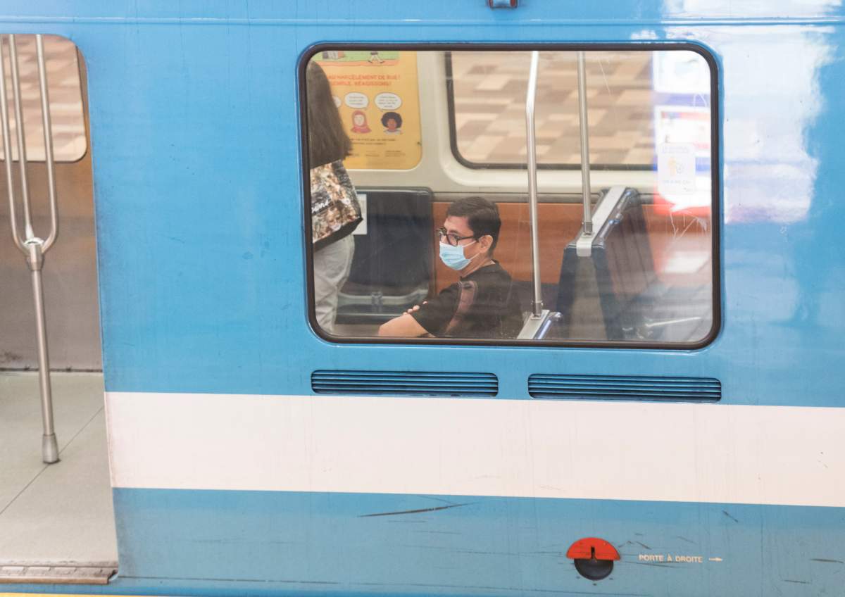 People wear face masks as they commute by metro in Montreal, Sunday, August 2, 2020, as the COVID-19 pandemic continues in Canada and around the world. 
