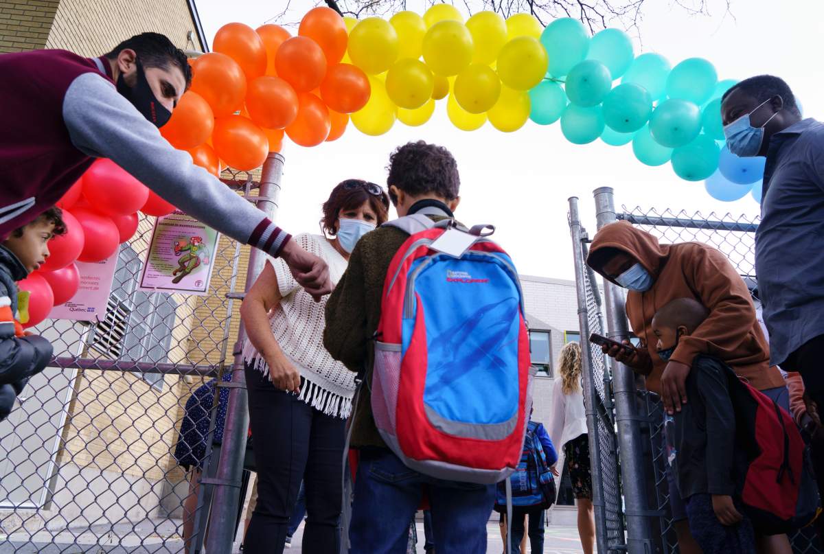 A student is greeted at the Philippe-Labarre Elementary School in Montreal, on Thursday, August 27, 2020. Thousands of Quebec students return to class in the shadow of the COVID-19 pandemic. 