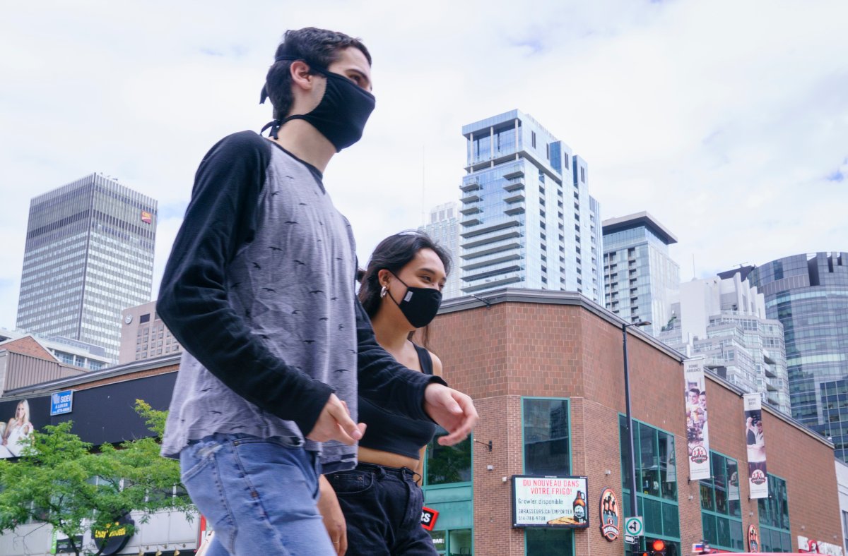 Pedestrians wearing protective masks walk down Montreal's Sainte-Catherine Street, on Tuesday, Sept. 1, 2020.