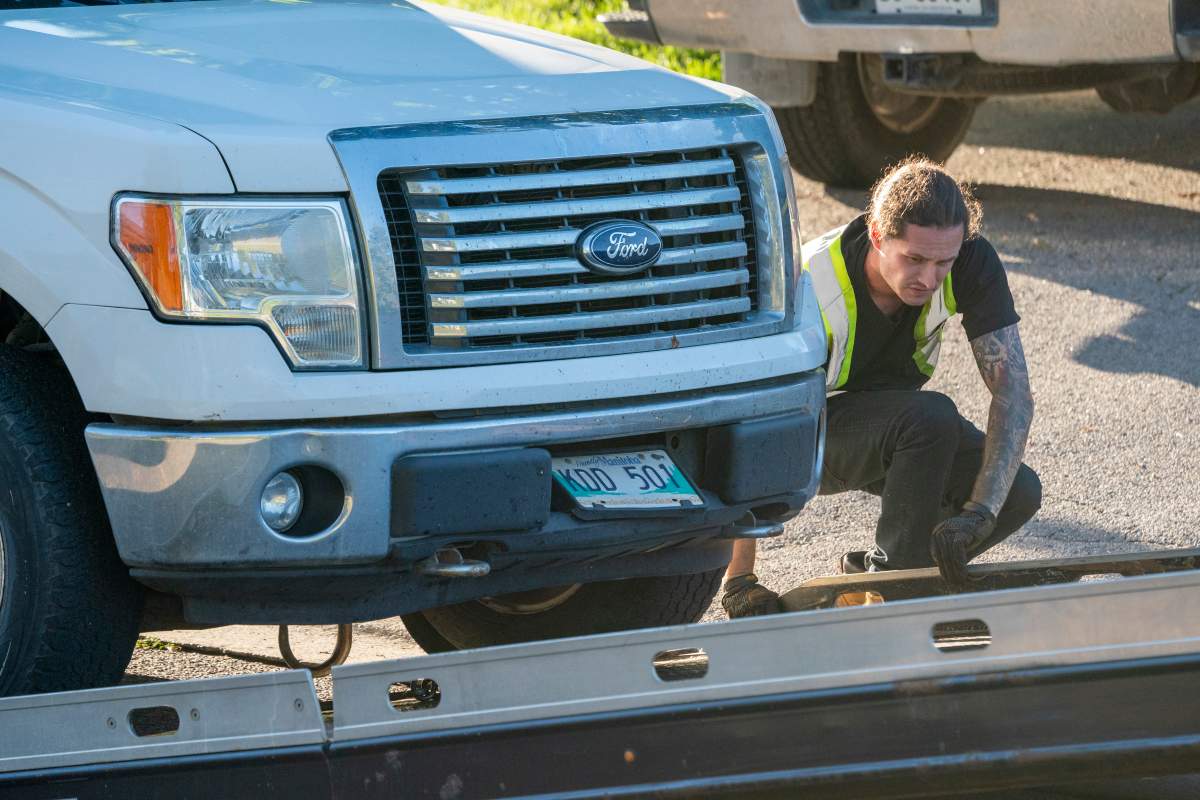 A tow truck operator removes a truck with Manitoba licence plates from the front of a home on Parklane Avenue in Oshawa, Ont. on Friday, September 4, 2020. Durham Regional Police say five people were found dead and another with serious injuries in the home east of Toronto after an early morning shooting. THE CANADIAN PRESS/Frank Gunn.