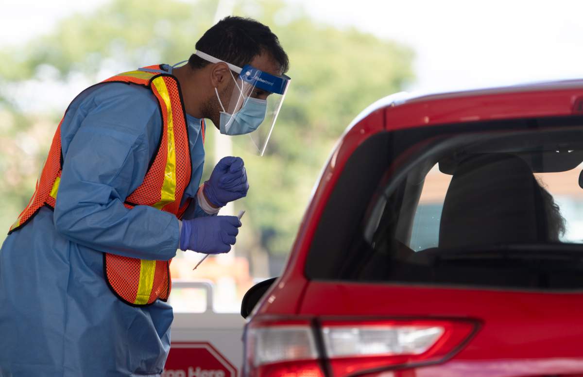 Ottawa health personnel speak with a driver before administering a COVID-19 test at a drive-thru test centre in Ottawa, Friday, Sept. 4, 2020. 