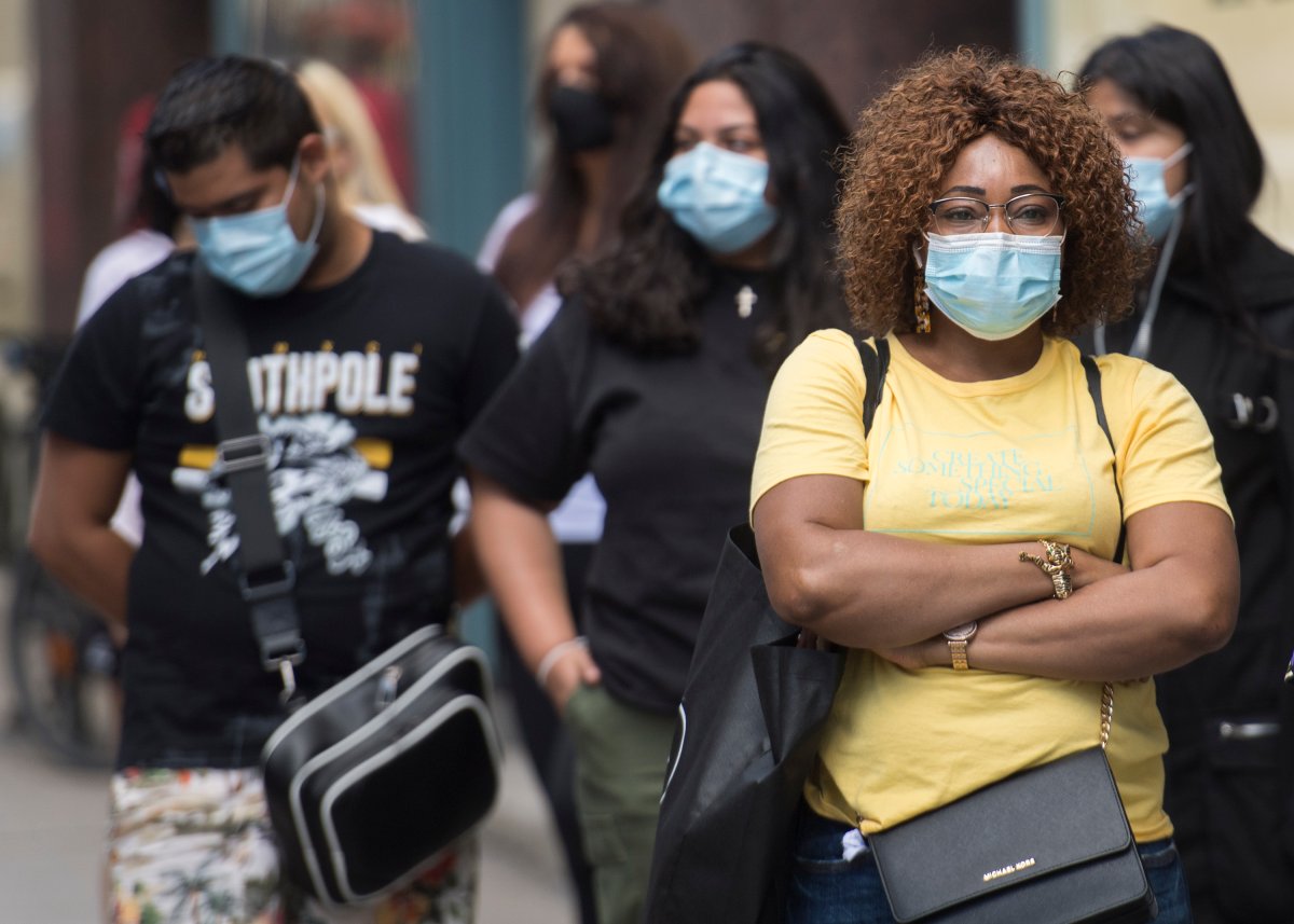People wear face masks as they wait to enter a store in Montreal, Saturday, Sept. 5, 2020, as the COVID-19 pandemic continues in Canada and around the world. 